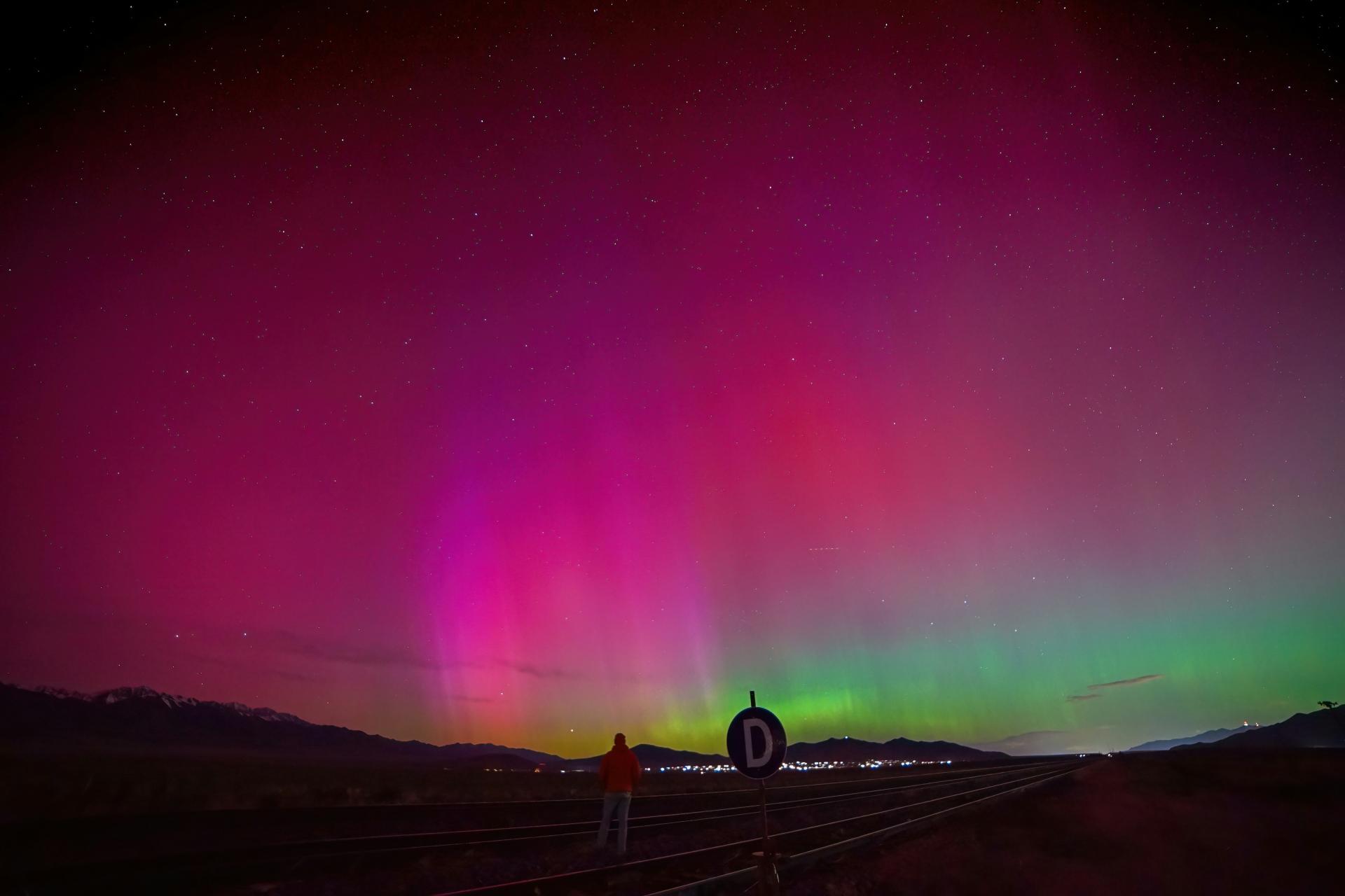 Vibrant northern lights over Colorado with colorful pink and purple skies illuminating the Rocky Mountain landscape at night.