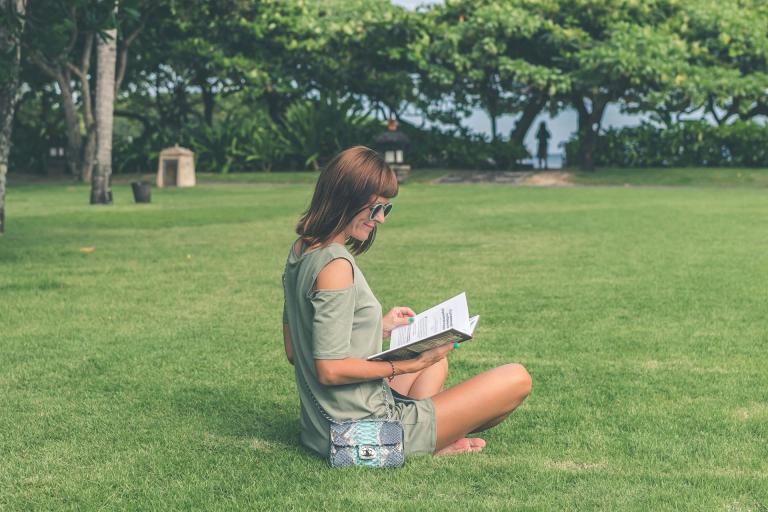 Woman sitting in park peacefully reading